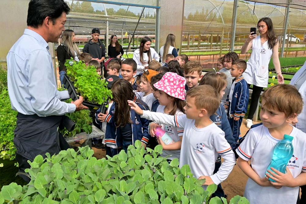 Alunos do Colégio Santa Marcelina aprendem sobre a origem dos alimentos durante visita guiada ao Viveiro Tomi. Foto Toninho Anhaia