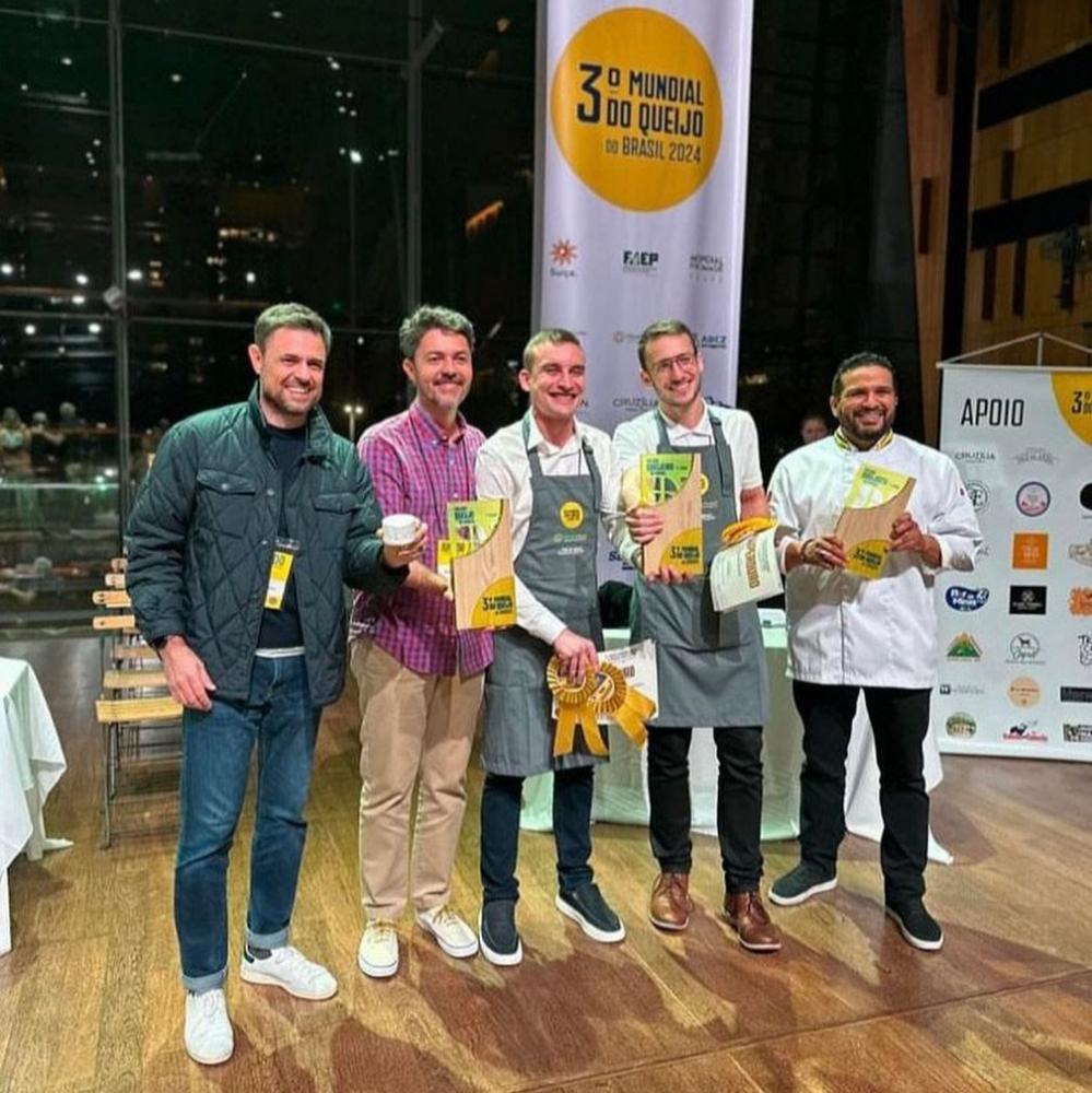 Da direita para esquerda: os irmãos Juliano e Bruno Mendes, proprietários do Laticínios Pomedore, vencedores com o queijo Morro Azul, no Concurso de Queijos e Produtos Lácteos. Ao centro aparecem Henrique Herbert, eleito Melhor Queijeiro, e Kennidy de Bor